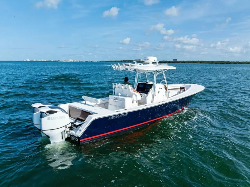 Slide: The Image of 2012 Regulator 32 FS boat cruising on open water under a clear blue sky. - 25