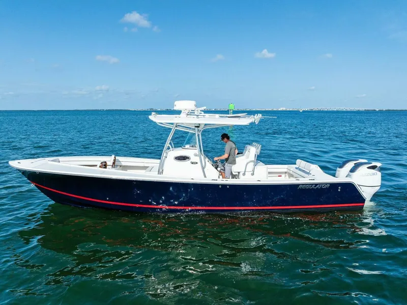 Slide: The Image of 2012 Regulator 32 FS boat on open water, clear sky, person onboard. - 26