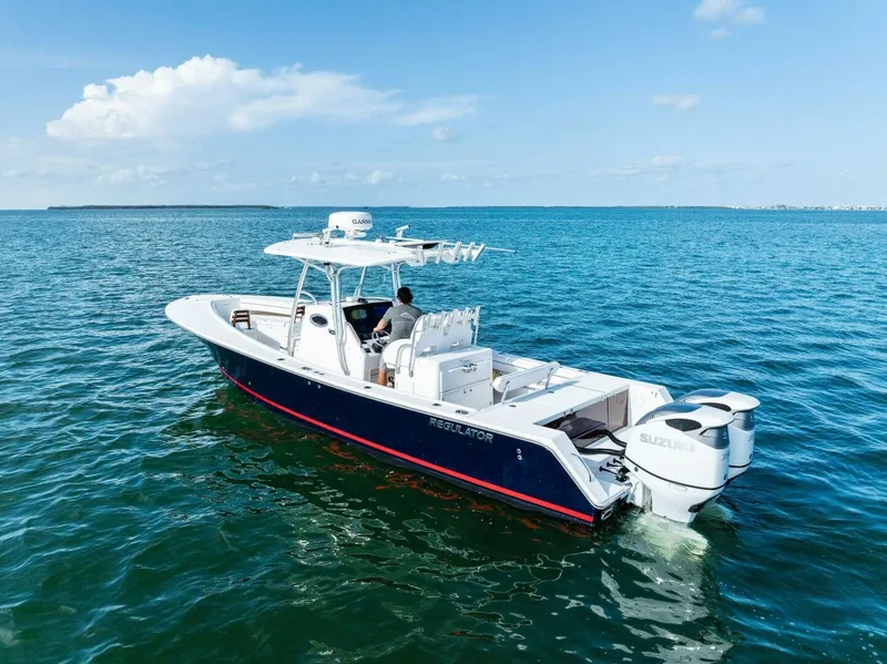 Slide: The Image of 2012 Regulator 32 FS boat on open water, featuring dual Suzuki engines. - 28