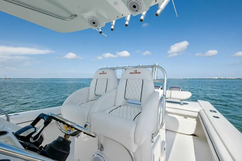 Slide: The Image of 2012 Regulator 32 FS boat interior with white seating, steering wheel, and ocean view. - 4