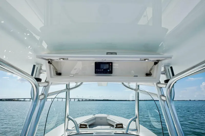 Slide: The Image of 2012 Regulator 32 FS boat interior with open console, ocean view, and bridge in background. - 9
