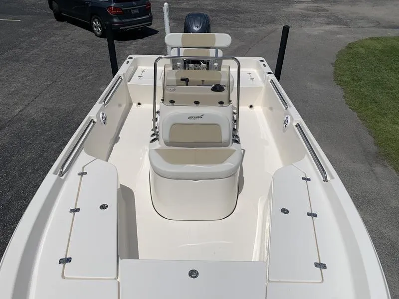 Slide: The Image of 2025 Bulls Bay 2200 boat interior with seating and console, parked on pavement. - 25