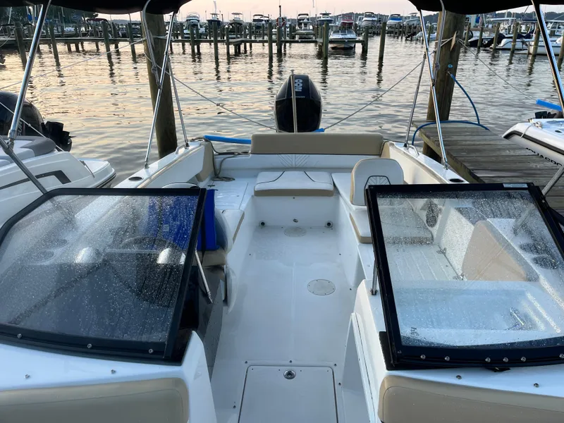 Slide: The Image of 2022 Glastron GTD 220 boat interior at a marina, featuring seating and windshield. - 3