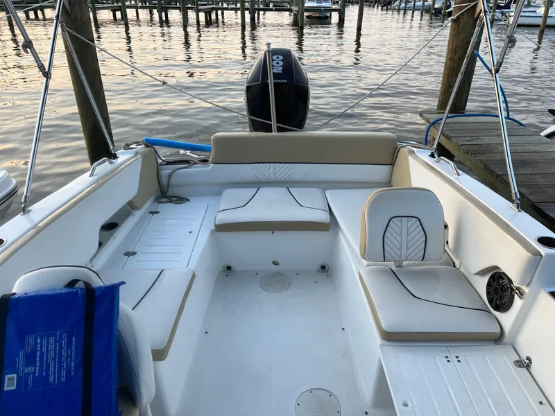 Slide: The Image of 2022 Glastron GTD 220 boat interior with seating, docked at a marina. - 4