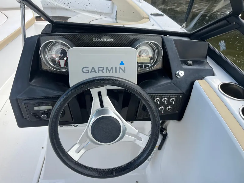 Slide: The Image of 2022 Glastron GTD 220 boat dashboard with Garmin navigation system and steering wheel. - 6