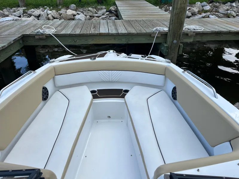 Slide: The Image of 2022 Glastron GTD 220 boat interior with beige seating, docked by wooden pier. - 7