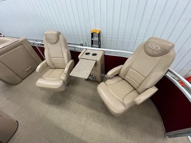 Slide: The Image of 2016 Harris Solstice 220 SL boat interior with beige captain chairs and center console. - 15