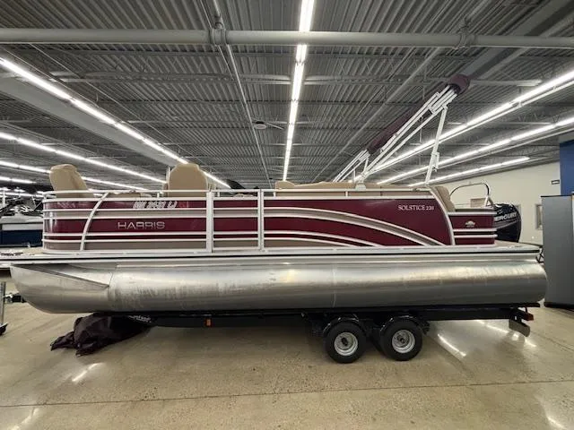 Slide: The Image of 2016 Harris Solstice 220 SL pontoon boat displayed indoors on a trailer. - 3