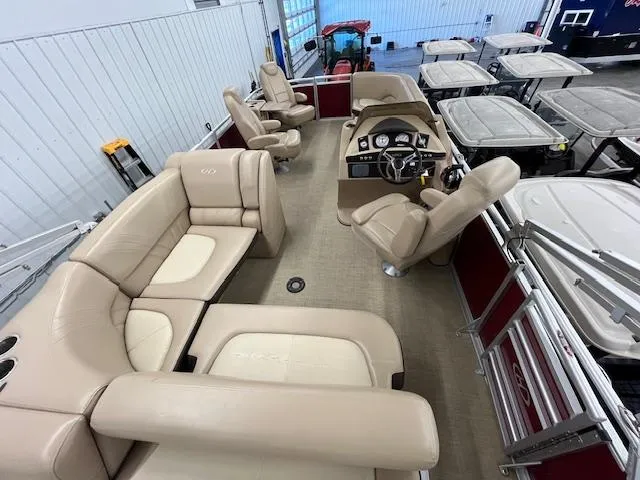 Slide: The Image of 2016 Harris Solstice 220 SL pontoon boat with beige seating and modern dashboard in a showroom. - 9