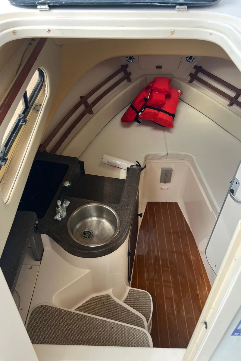 Slide: The Image of 2008 Grady-White 282 Sailfish WA cabin interior with sink, wooden floor, and life jackets. - 37