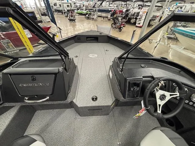 Slide: The Image of 2025 Crestliner 2050 Fish Hawk boat interior with steering wheel and dashboard in showroom. - 16