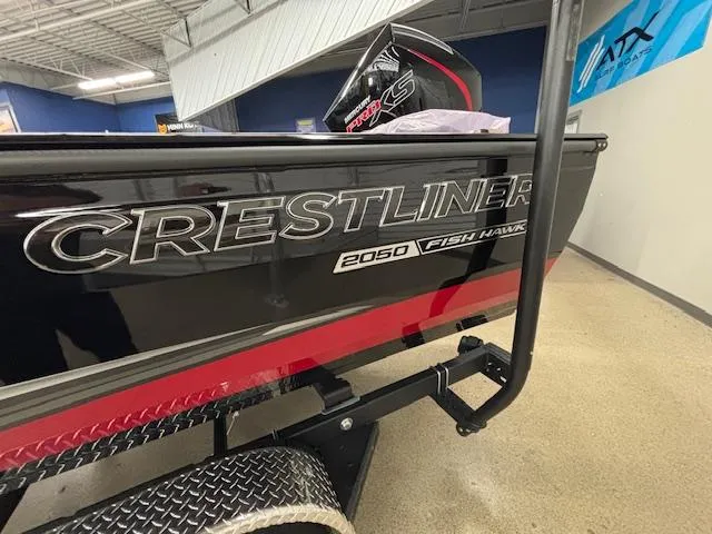 Slide: The Image of 2025 Crestliner 2050 Fish Hawk boat in showroom, side view with logo. - 2