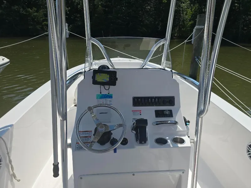 Slide: The Image of 2023 Aquasport 2200 Center Console boat dashboard with steering wheel and controls. - 3