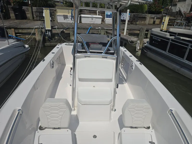 Slide: The Image of 2023 Aquasport 2200 Center Console boat interior at dock, featuring seating and console. - 5