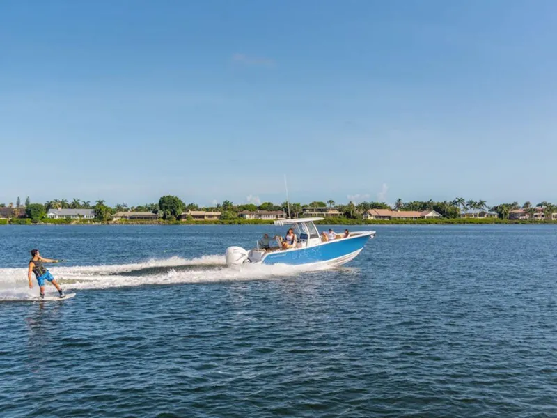 Slide: The Image of 2026 Sportsman Heritage 261 boat towing a wakeboarder on a sunny lake. - 5