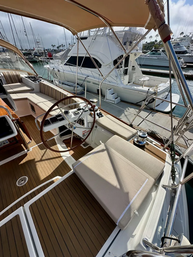 Slide: The Image of 2014 Jeanneau 57 yacht interior with wooden deck and steering wheel at marina. - 21