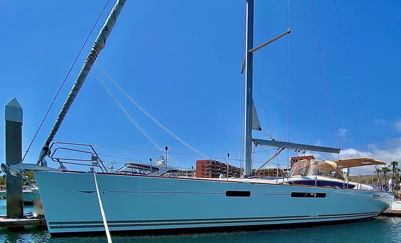 Slide: The Image of 2014 Jeanneau 57 sailboat docked in marina under clear blue sky. - 6