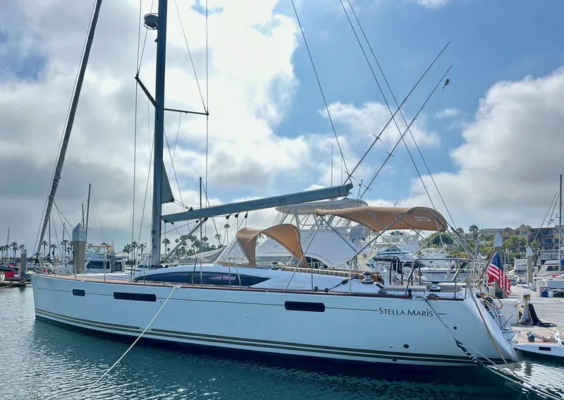 Slide: The Image of 2014 Jeanneau 57 yacht docked in a marina under a partly cloudy sky. - 7