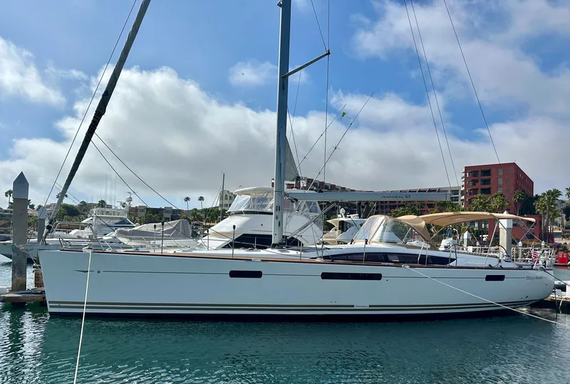 Slide: The Image of 2014 Jeanneau 57 yacht docked in a marina under a clear blue sky. - 8