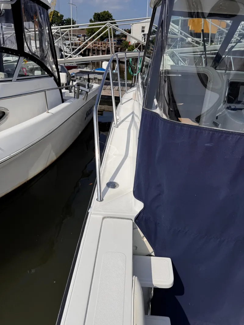 Slide: The Image of 2004 Glacier Bay 2680 Coastal Runner docked, featuring sleek design and blue cover. - 11