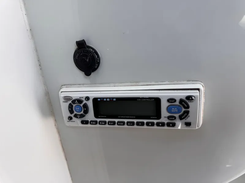 Slide: The Image of 2004 Glacier Bay 2680 Coastal Runner control panel with radio and power socket. - 15