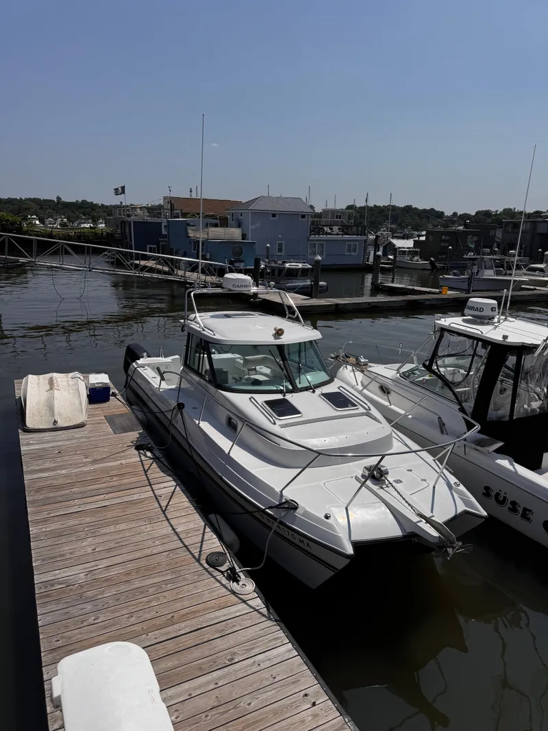 Slide: The Image of 2004 Glacier Bay 2680 Coastal Runner docked at marina under clear sky. - 2