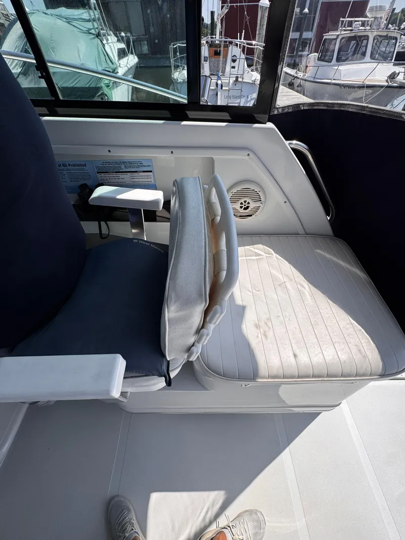 Slide: The Image of 2004 Glacier Bay 2680 Coastal Runner interior seating with window view of docked boats. - 22