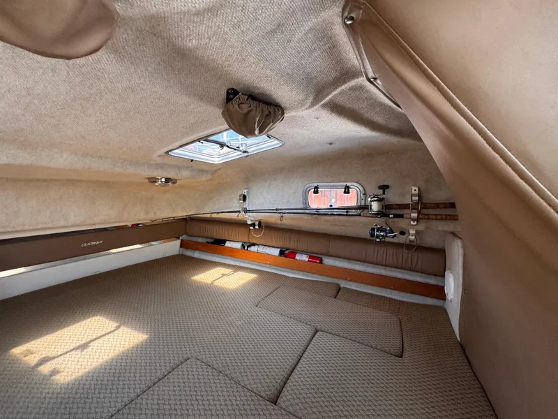 Slide: The Image of 2004 Glacier Bay 2680 Coastal Runner cabin interior with fishing gear and beige upholstery. - 36