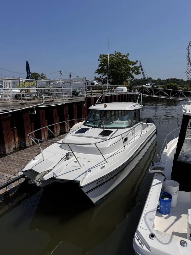 Slide: The Image of 2004 Glacier Bay 2680 Coastal Runner boat docked at marina under clear blue sky. - 4