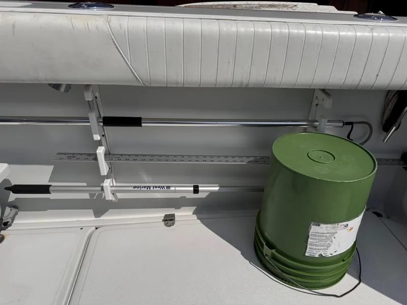 Slide: The Image of 2004 Glacier Bay 2680 Coastal Runner interior with green bucket and fishing rod holder. - 42