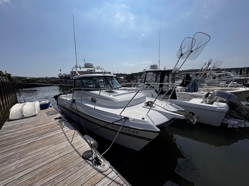 Slide: The Image of 2004 Glacier Bay 2680 Coastal Runner docked at marina under clear sky. - 5