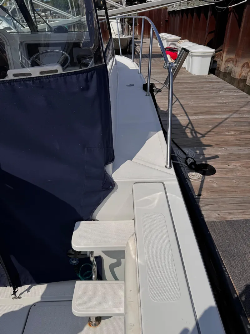 Slide: The Image of 2004 Glacier Bay 2680 Coastal Runner docked, showing deck and railing details. - 9