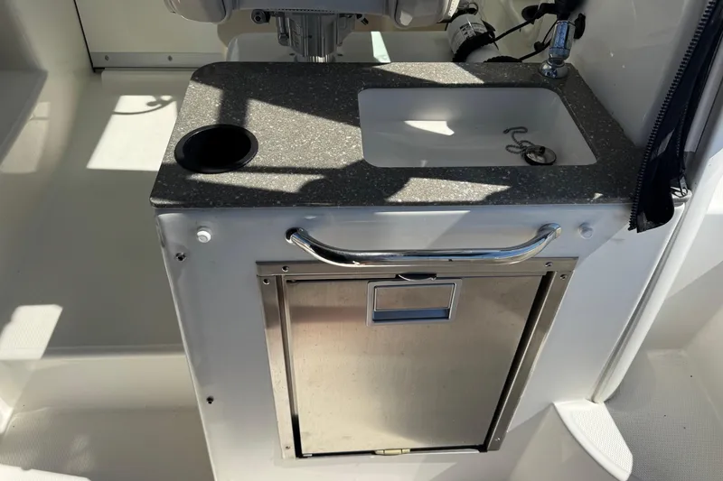 Slide: The Image of 2018 Boston Whaler 285 Conquest boat sink and storage area with stainless steel finish. - 14