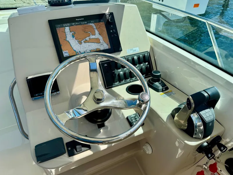 Slide: The Image of 2018 Boston Whaler 285 Conquest helm with navigation display and controls. - 16