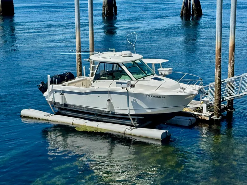 Slide: The Image of 2018 Boston Whaler 285 Conquest boat docked on calm water. - 2