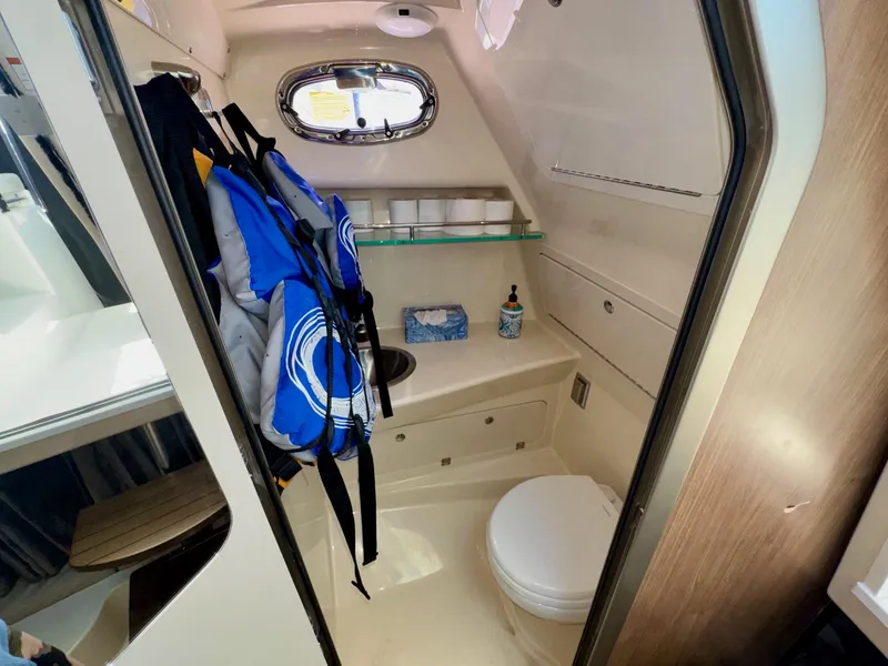 Slide: The Image of 2018 Boston Whaler 285 Conquest bathroom with life jackets, toilet, and sink. - 25