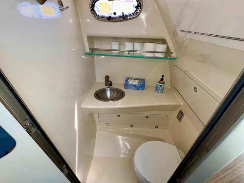 Slide: The Image of 2018 Boston Whaler 285 Conquest bathroom with sink, toilet, and storage shelves. - 26