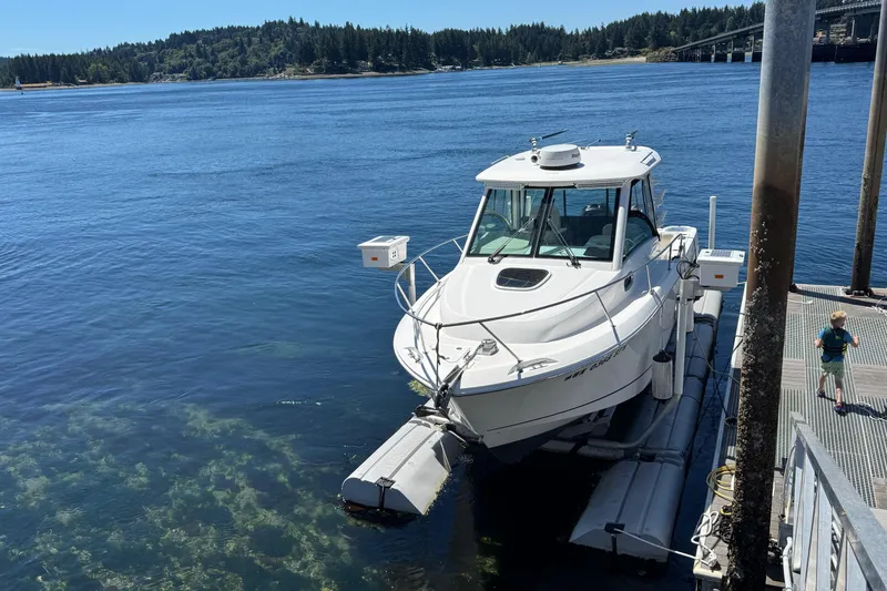Slide: The Image of 2018 Boston Whaler 285 Conquest docked on a sunny day by the water. - 32