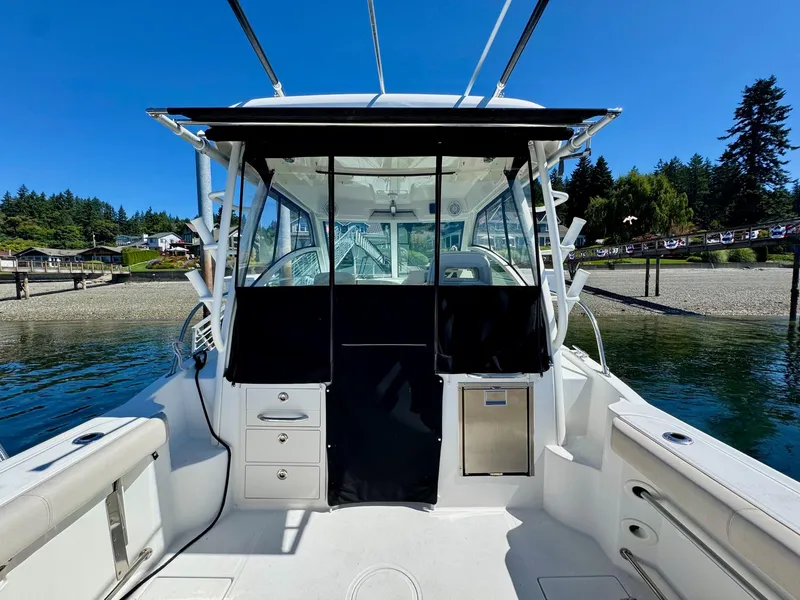Slide: The Image of 2018 Boston Whaler 285 Conquest boat docked by scenic shoreline. - 7