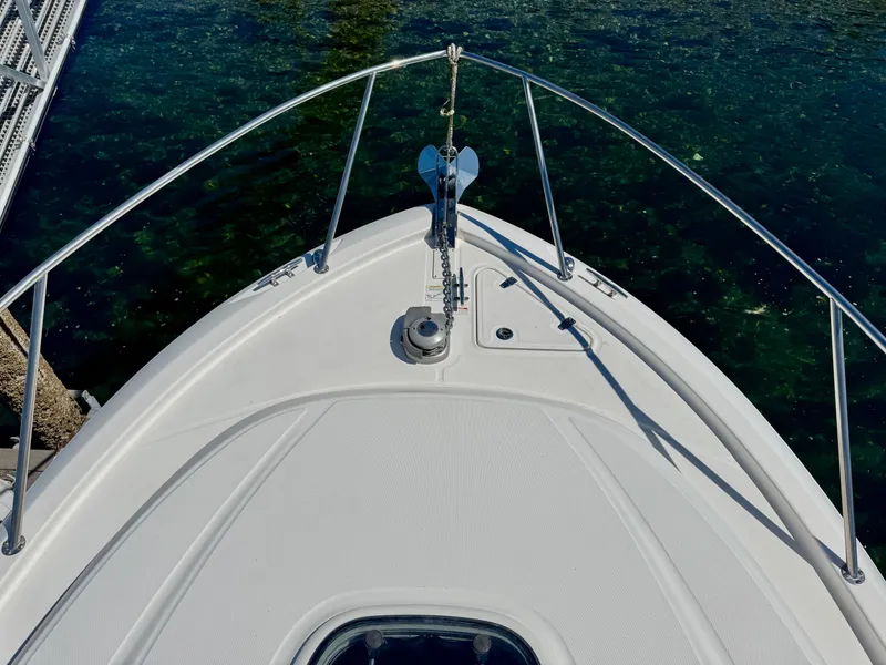 Slide: The Image of Bow of 2018 Boston Whaler 285 Conquest boat with anchor, docked on clear water. - 8