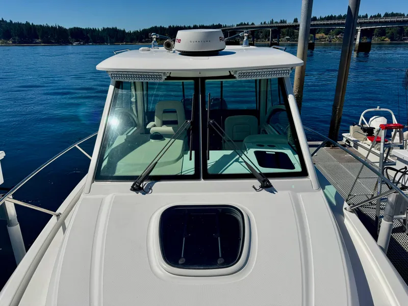 Slide: The Image of 2018 Boston Whaler 285 Conquest docked by a scenic waterfront. - 9