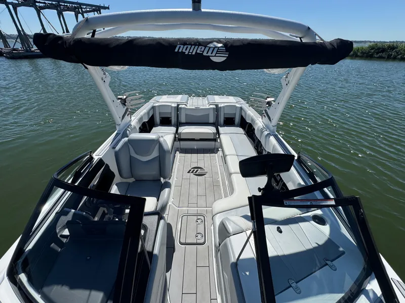 Slide: The Image of 2022 Malibu Wakesetter 24 MXZ boat interior with spacious seating on a sunny day. - 12
