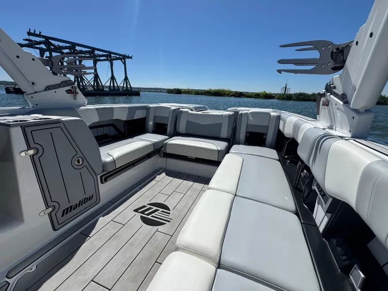 Slide: The Image of 2022 Malibu Wakesetter 24 MXZ interior with spacious seating and sleek design on a sunny day. - 17