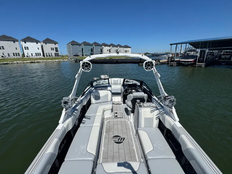 Slide: The Image of 2022 Malibu Wakesetter 24 MXZ boat on water, modern design, spacious seating, clear sky. - 22