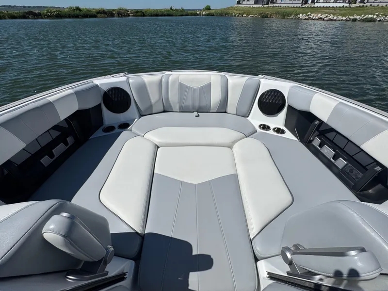 Slide: The Image of 2022 Malibu Wakesetter 24 MXZ boat interior with gray and white seating. - 9