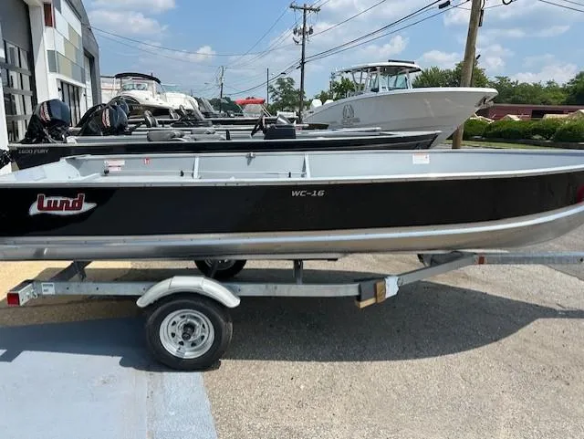 The Image of 2026 Lund WC-16 boat on trailer, parked outdoors under a clear sky. - 0