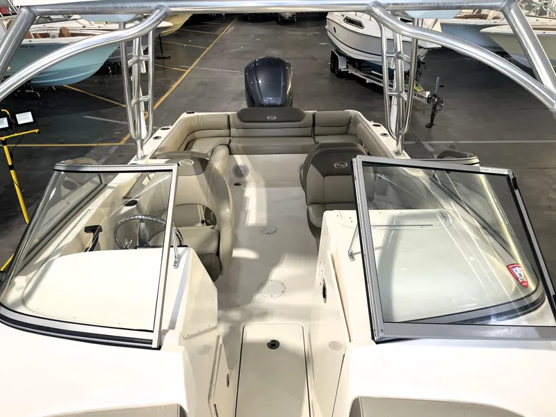 Slide: The Image of 2023 Key West 239 DFS boat interior with seating and steering wheel in a showroom. - 21