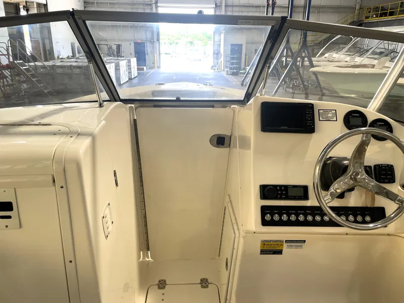 Slide: The Image of 2023 Key West 239 DFS boat interior with steering wheel and dashboard controls. - 23