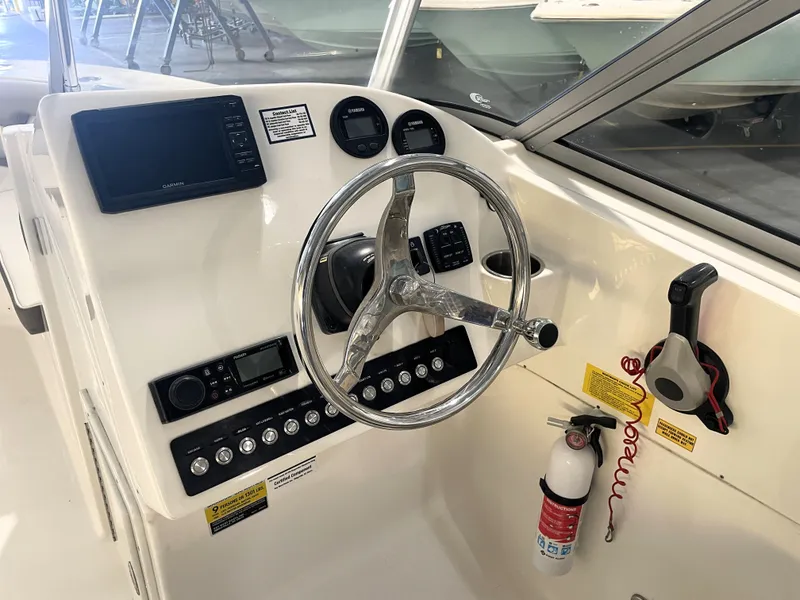 Slide: The Image of 2023 Key West 239 DFS boat dashboard with steering wheel and controls. - 25