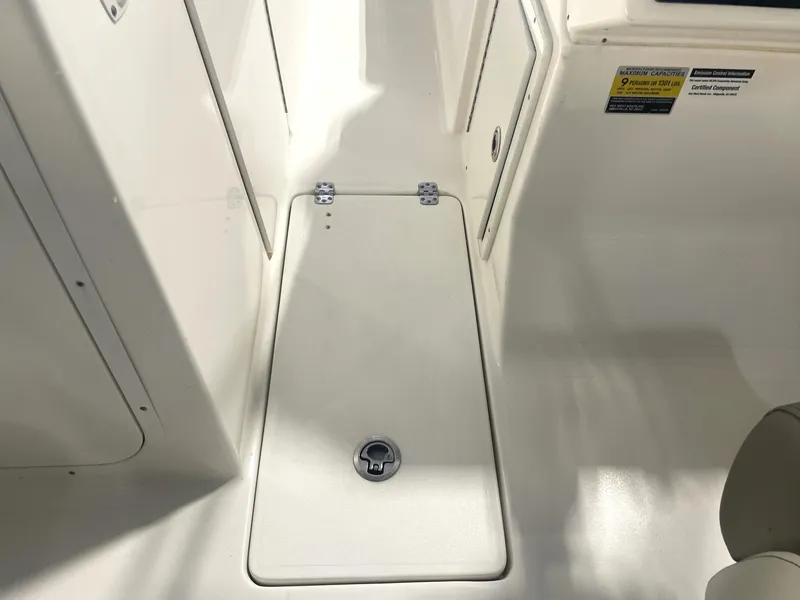 Slide: The Image of 2023 Key West 239 DFS boat interior with storage compartment and capacity label. - 37